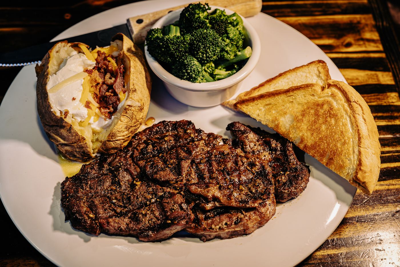 Hand-cut seared ribeye with loaded baked potato and broccoli