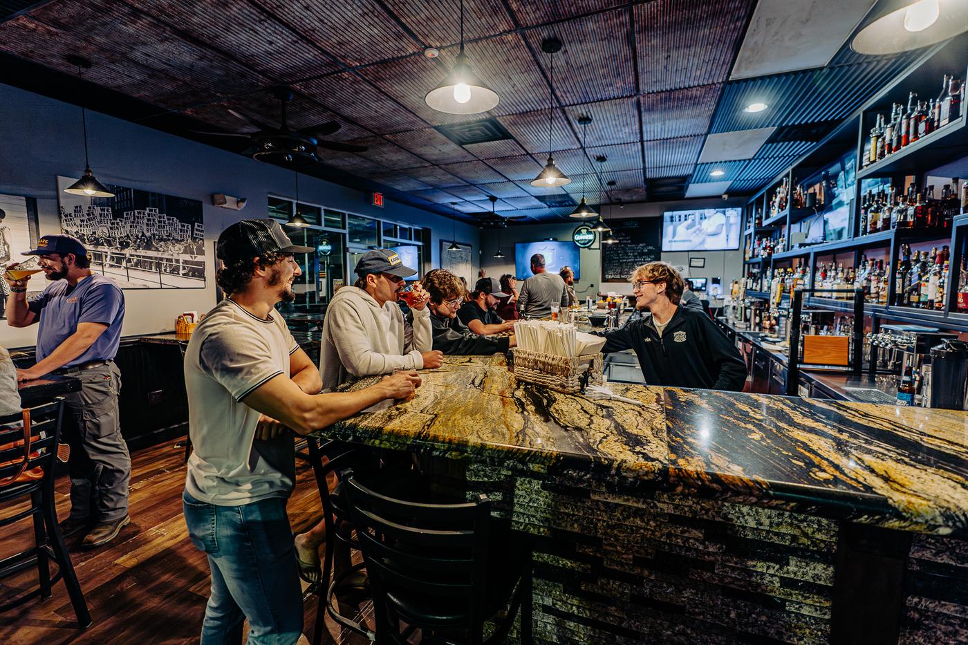 StokeRidge bar with granite bar top, tin ceiling, and bourbon shelf